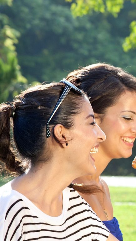 Group of people laughing and having a picnic cheer-sing cups 